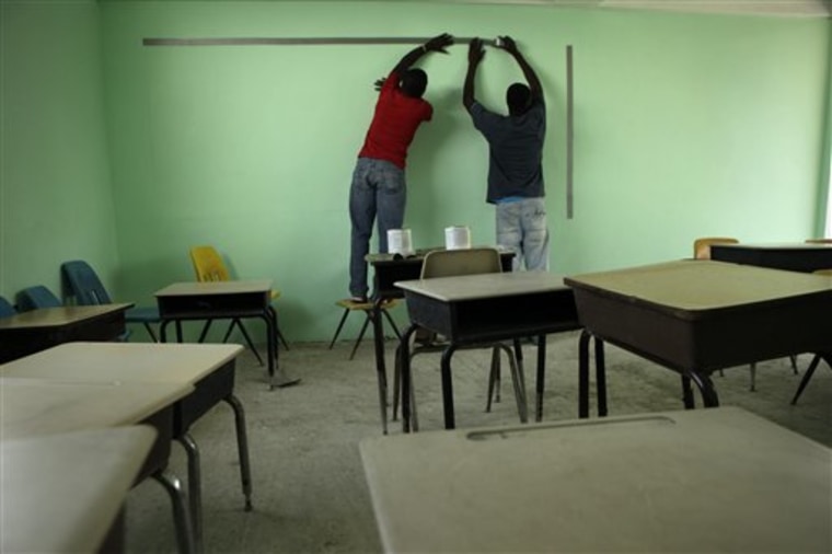 Men use tape to mark off an area to create a blackboard at the Christian Light Ministries school in Port-au-Prince, Haiti, on Aug. 25. In the seven months since the earthquake, the 62-year-old Sherrie Fausey from Jacksonville, Fla., has constructed a new school building for her 200 students. She's also tripled the salaries for her 22 teachers.